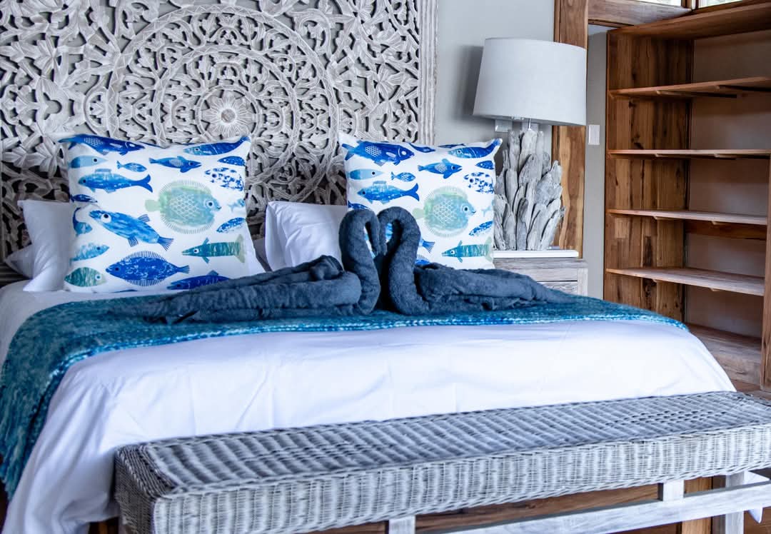 Beach villa bedroom with carved mandala headboard