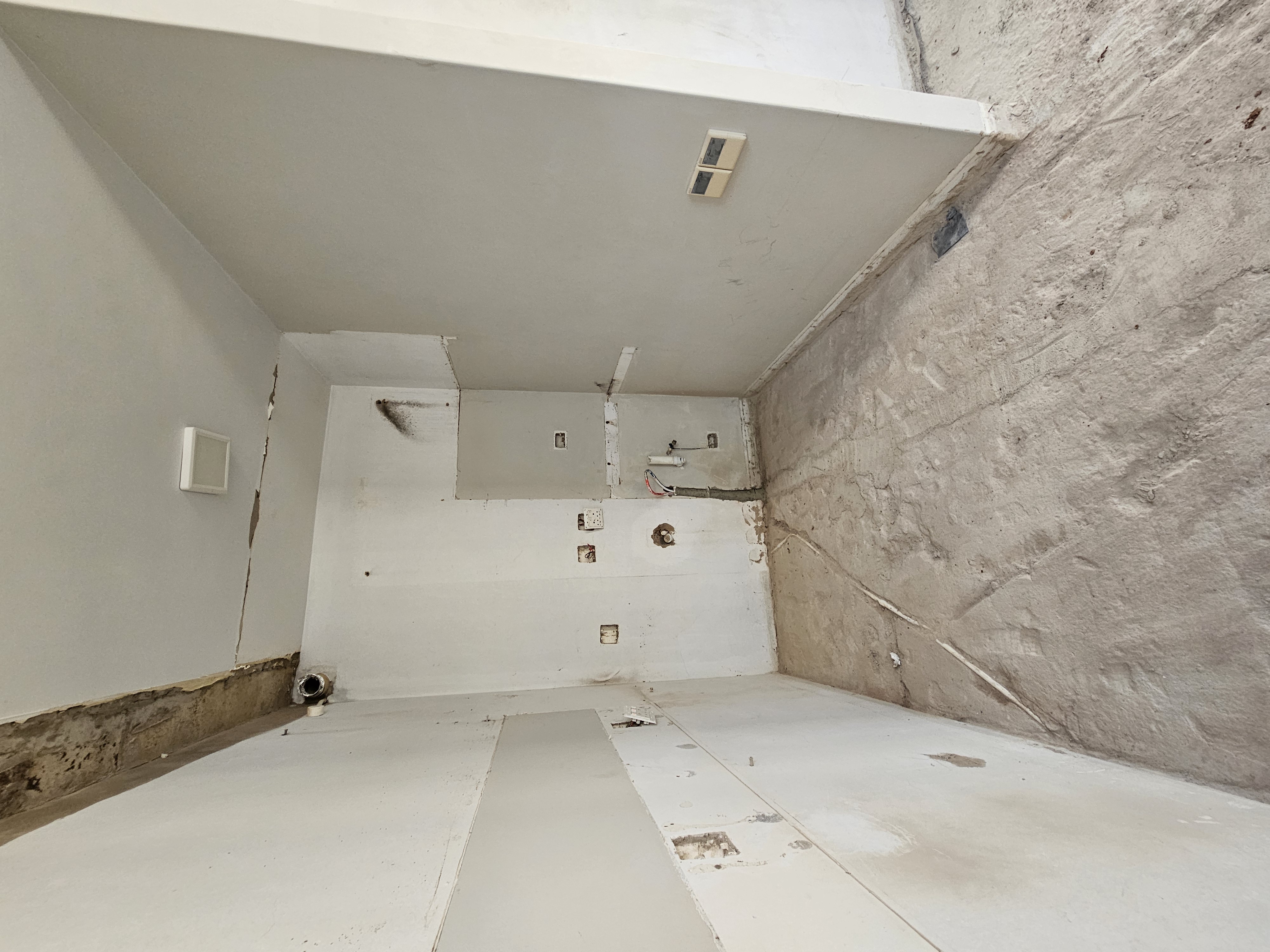 Kitchen and scullery space prepared for custom cabinetry with electrical and plumbing points installed