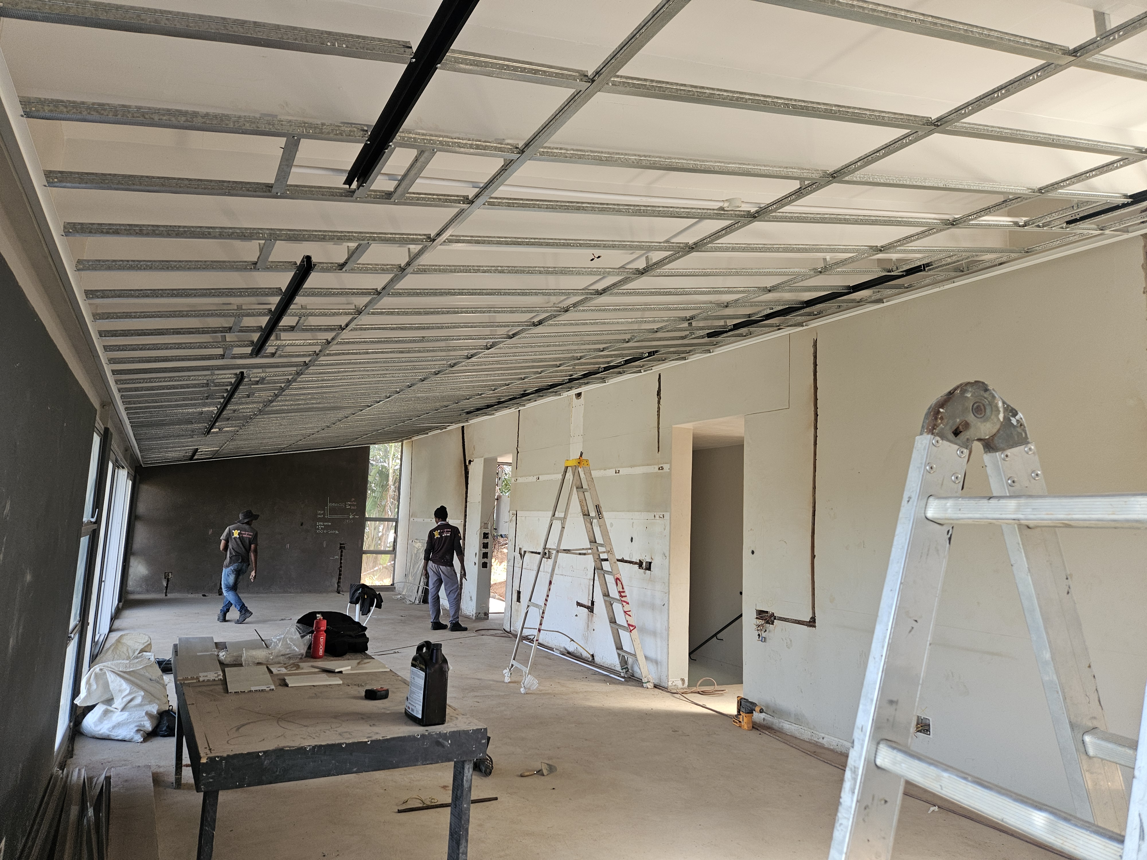 New ceiling grid and drywall installation in open plan living space during full home renovation Durban
