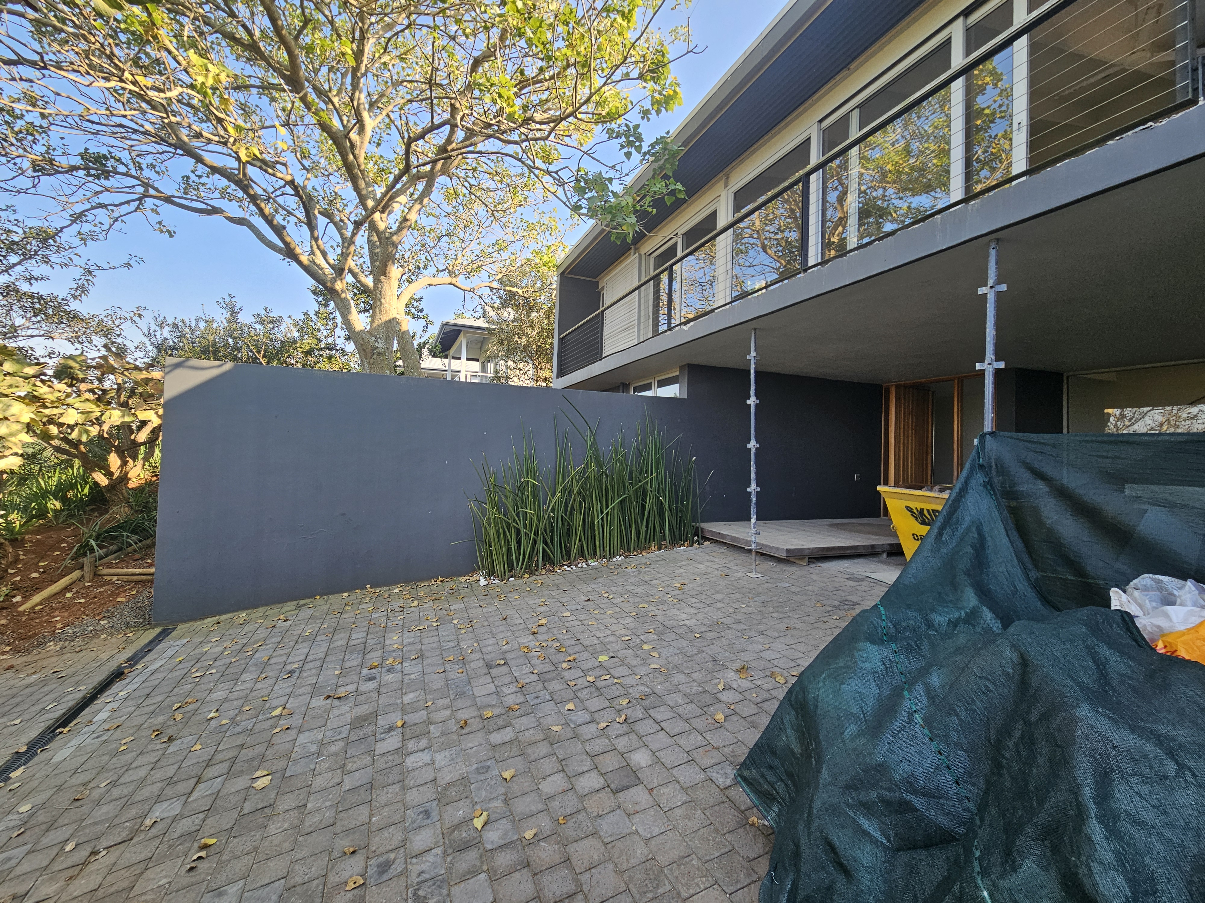 Modern two-storey home exterior renovation with new paving and timber entrance by interior designer Durban